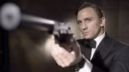 Daniel Craig as James Bond pointing a silenced pistol.