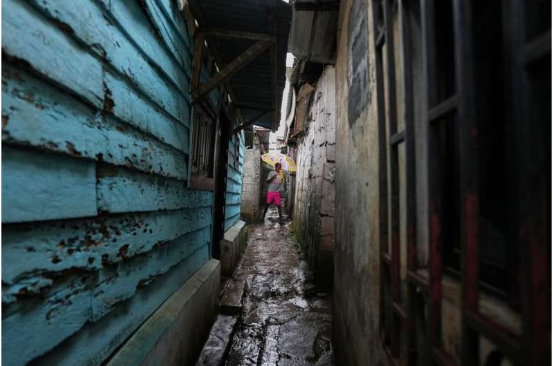 A resident walks through a narrow alley in a neighborhood where MCD Global Health workers are spraying insecticide to help prevent the spread of malaria in Malabo, Equatorial Guinea, April 24, 2026. Credit: AP Photo/Misper Apawu Equatorial Guinea Malaria