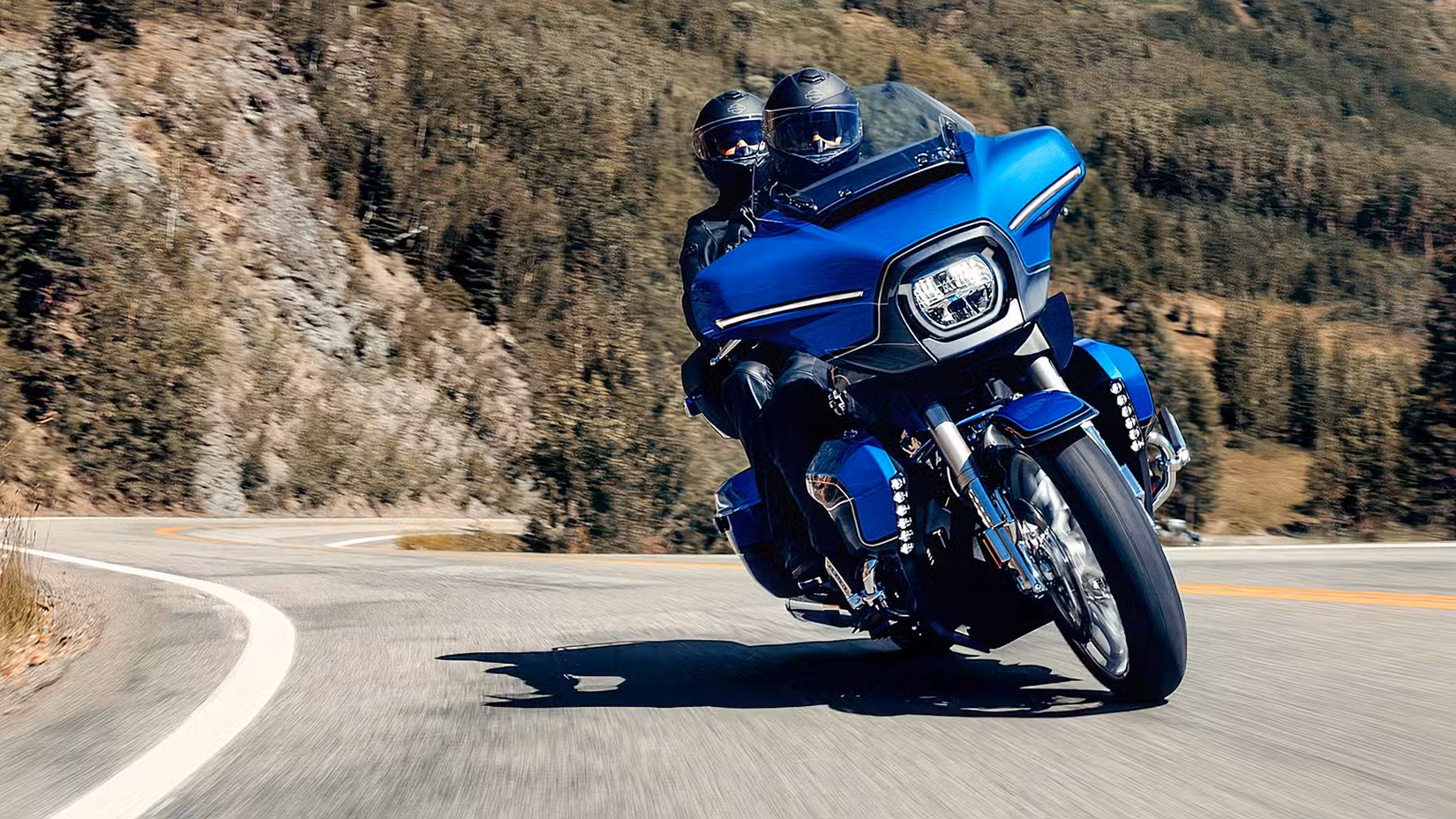 2026 Harley-Davidson CVO Street Glide Limited cornering on a mountain road with rider and pillion