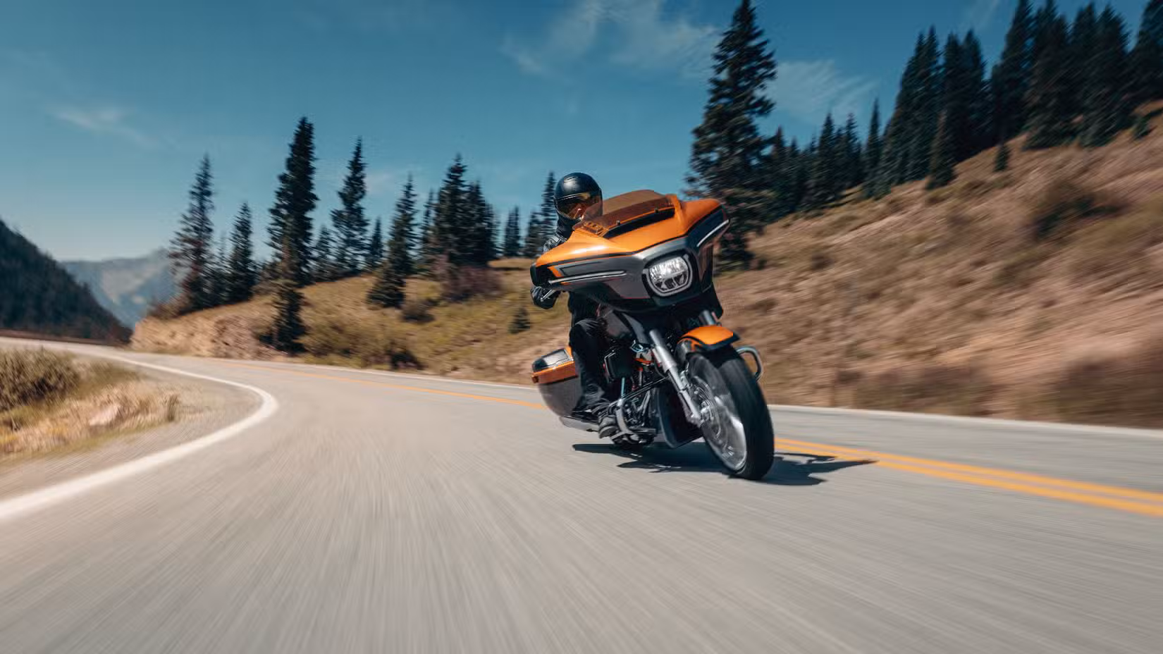 Harley-Davidson CVO Street Glide riding on a curve on a deserted highway