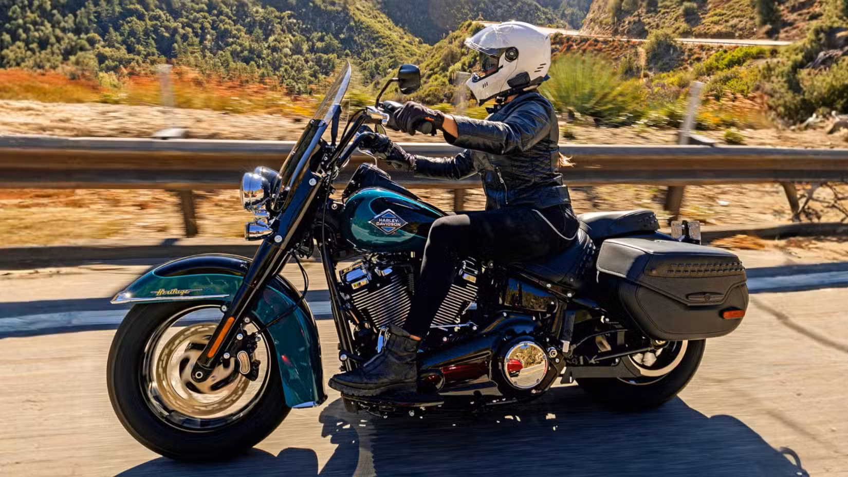 Rider on a blue 2026 Harley-Davidson Heritage Classic, side profile shot