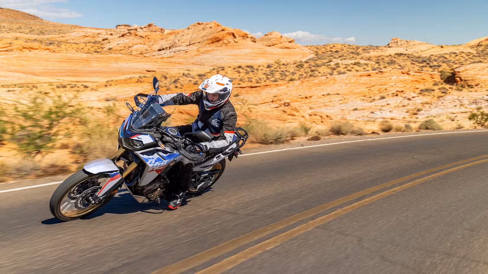 2026 Honda Africa Twin Adventure Sports cornering on a road in the desert