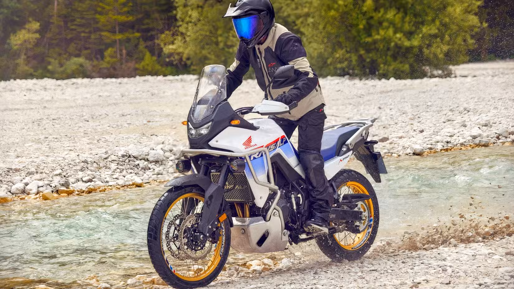 Action shot of a Honda XL750 Transalp riding on a riverbed