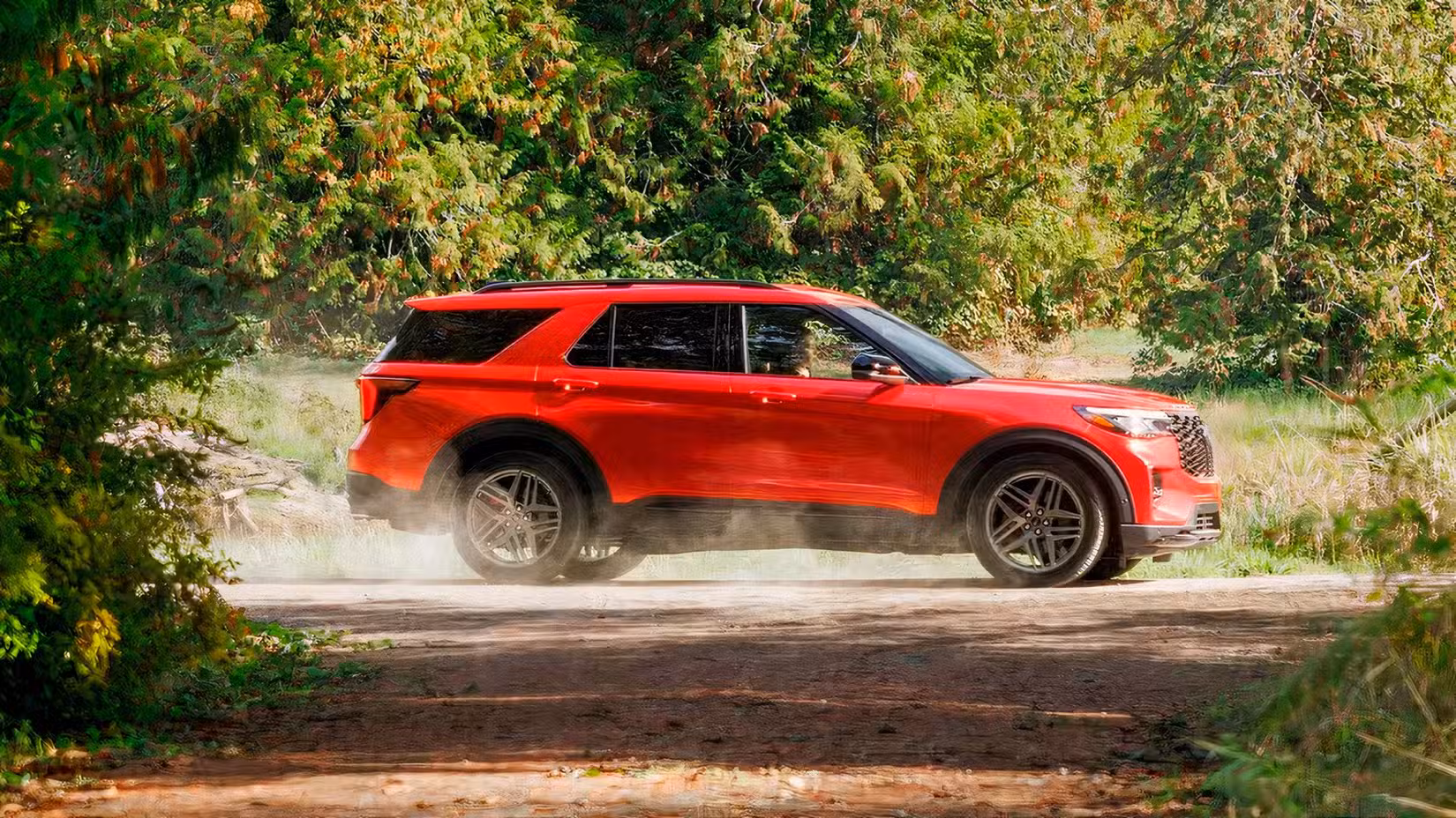 Profile action shot of 2026 Ford Explorer ST in red driving off-road
