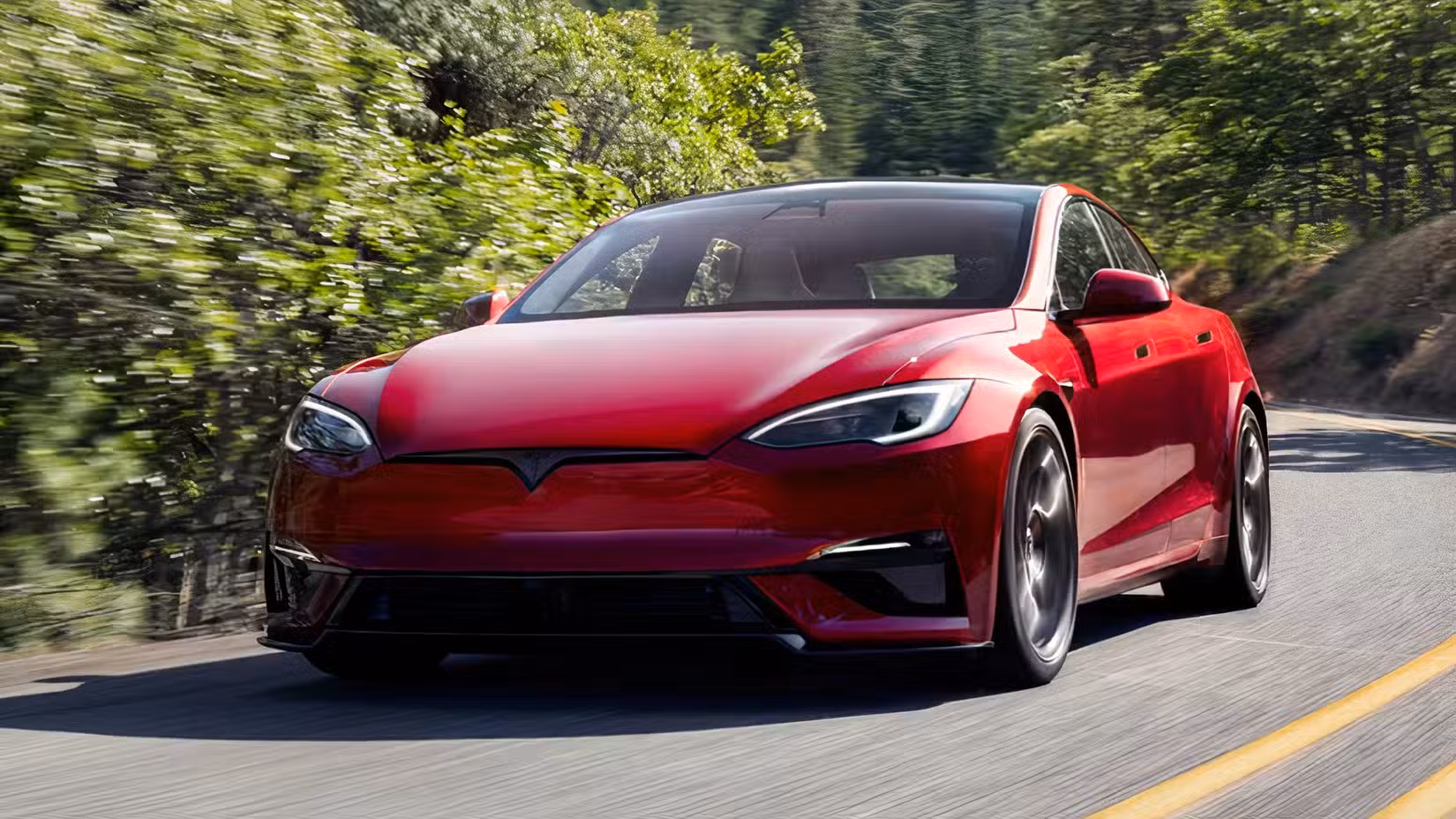 Front 3/4 action shot of 2026 Tesla Model S Plaid in red being driven on road