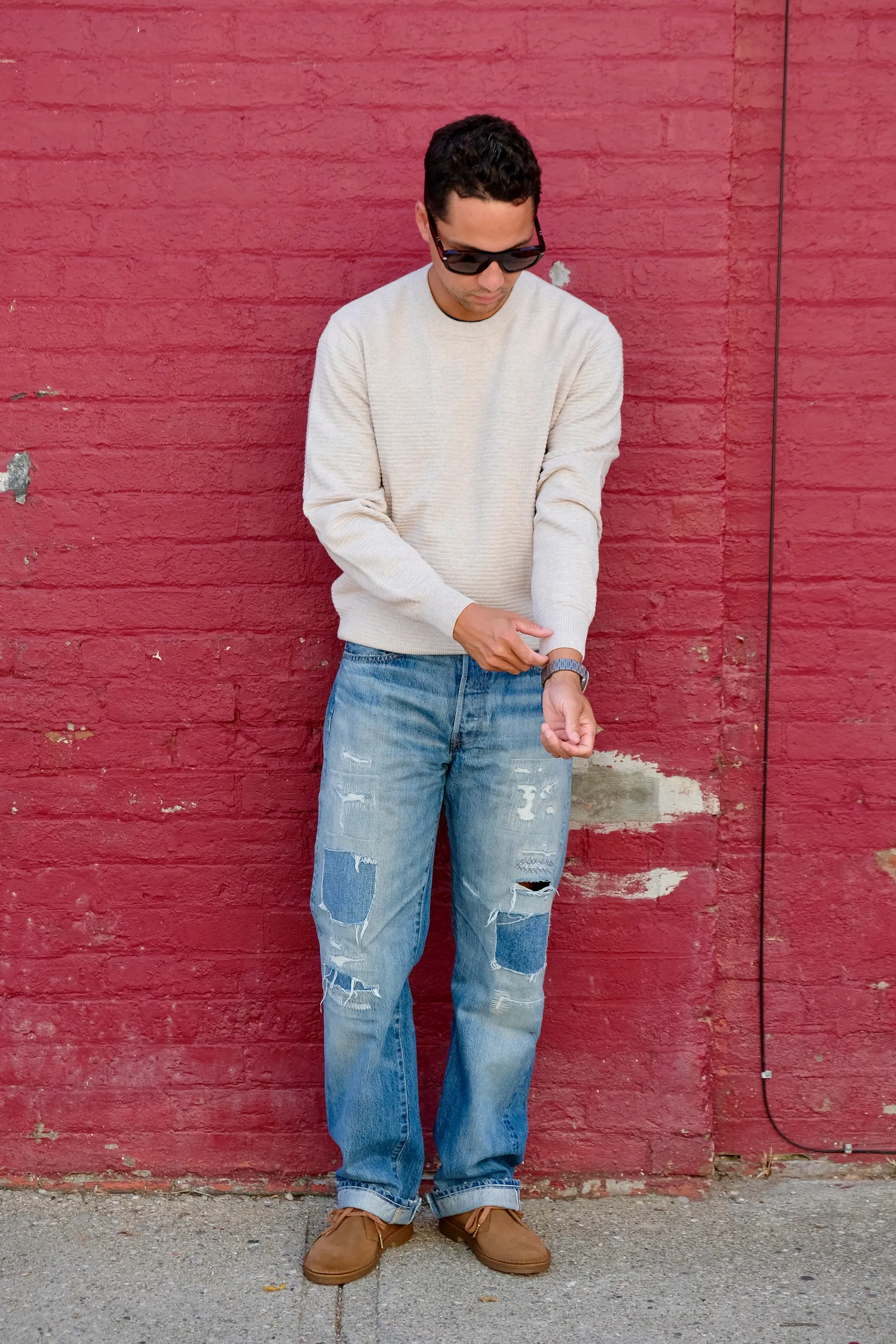 Image may contain Clothing Pants Jeans Adult Person Standing Knitwear and Sweater
