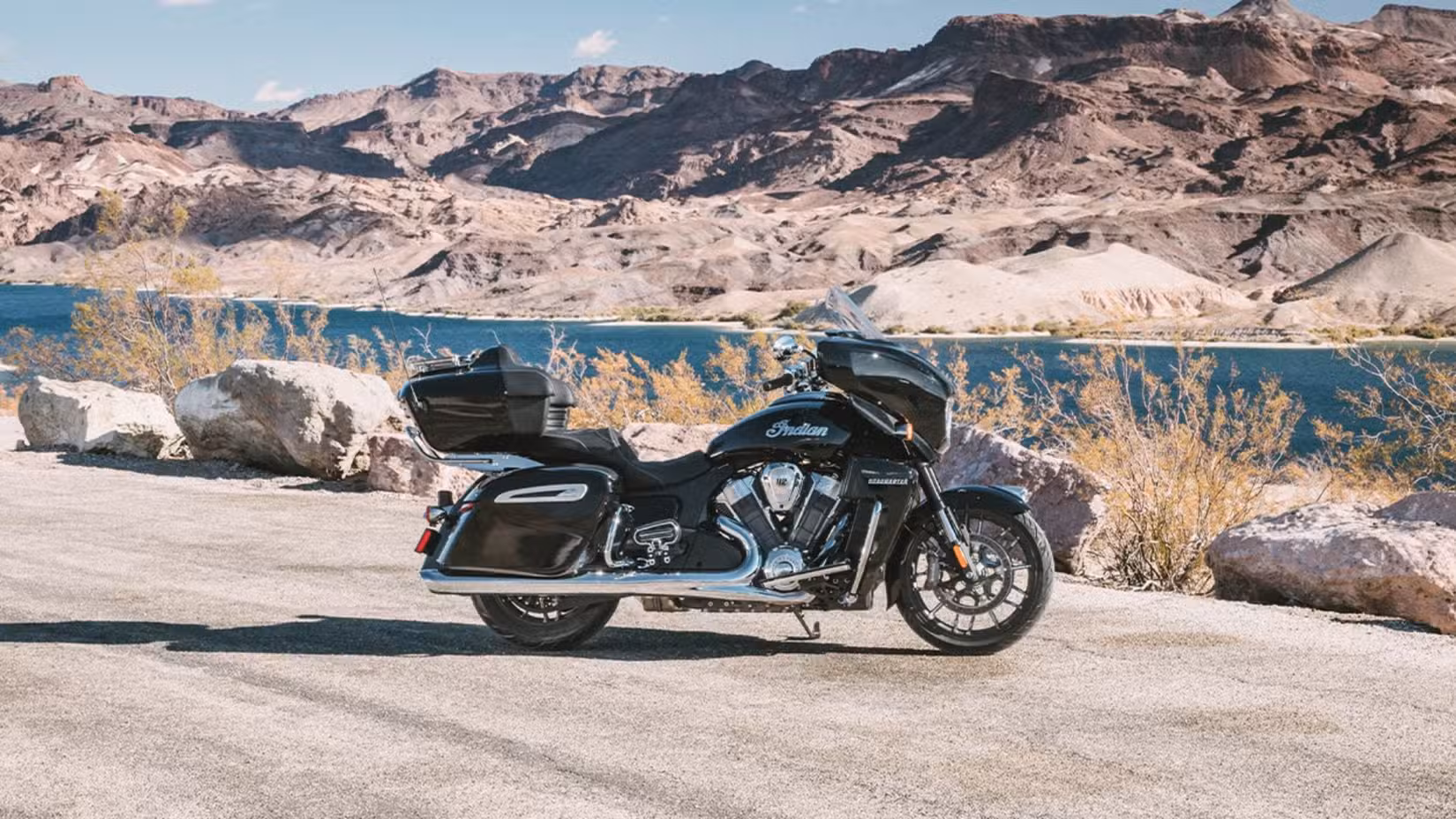 Static side profile shot of Indian Roadmaster Powerplus in front of a lake