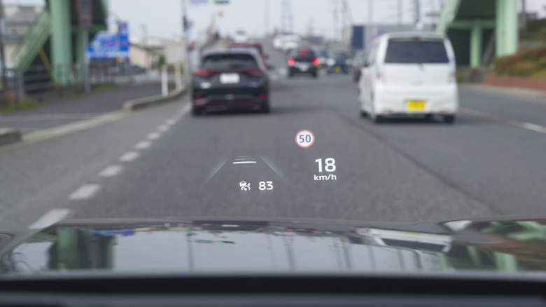 A heads-up display showing the speed limit and current speed, alongside adaptive cruise control speed settings.
