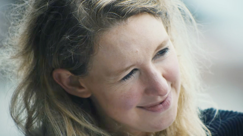 Elizabeth Holmes smiling outside on a beach in You Can See Everything
