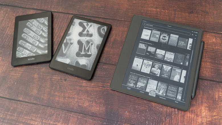 Three models of Kindle devices resting side by side on a table
