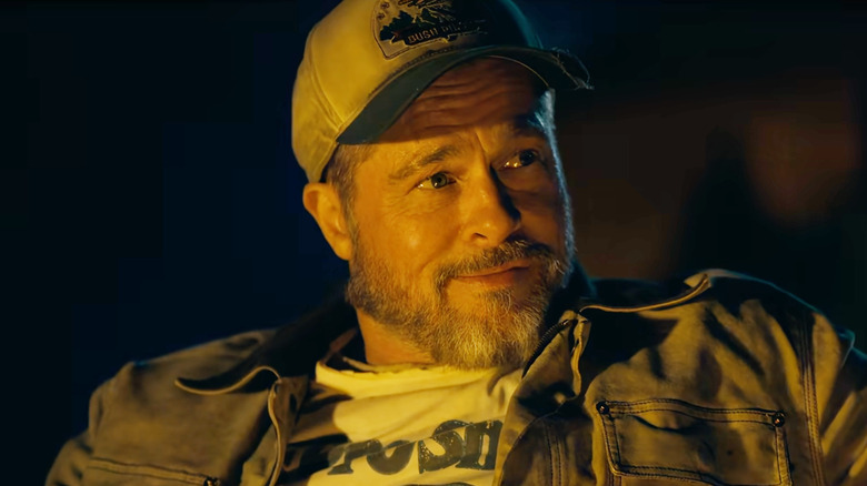 Brad Pitt as James Belmont wearing a baseball cap at night in Heart of the Beast