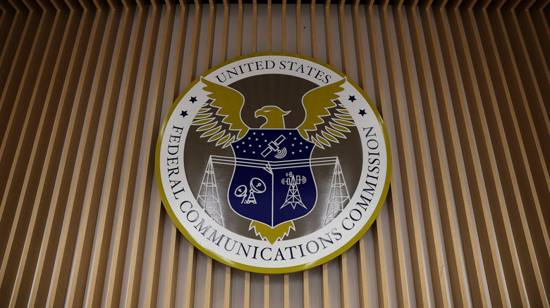 Photo of the FCC insignia displayed on a wall in the agency's briefing room.