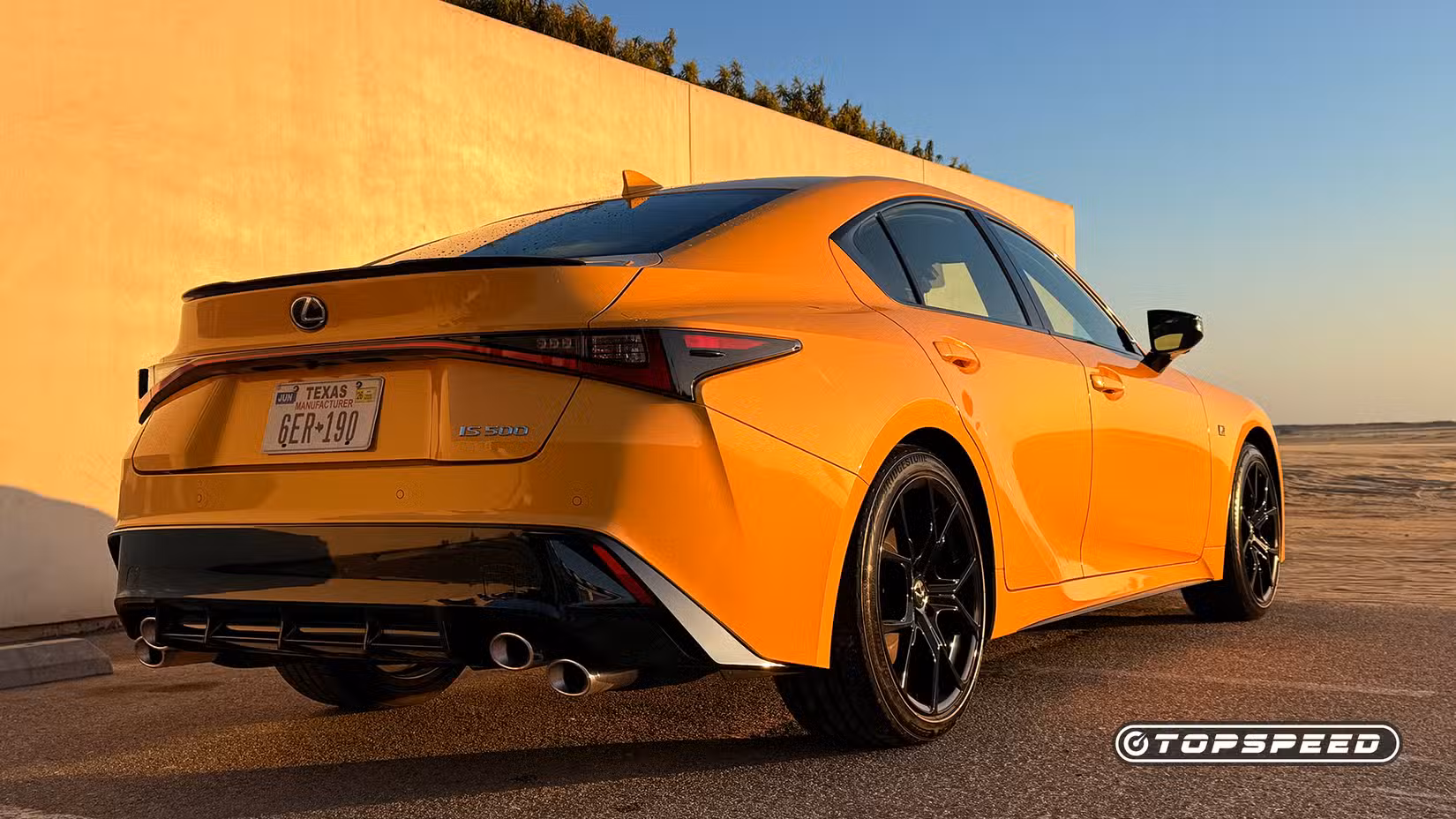 Rear 3/4 shot of 2025 Lexus IS500 parked in front of wall