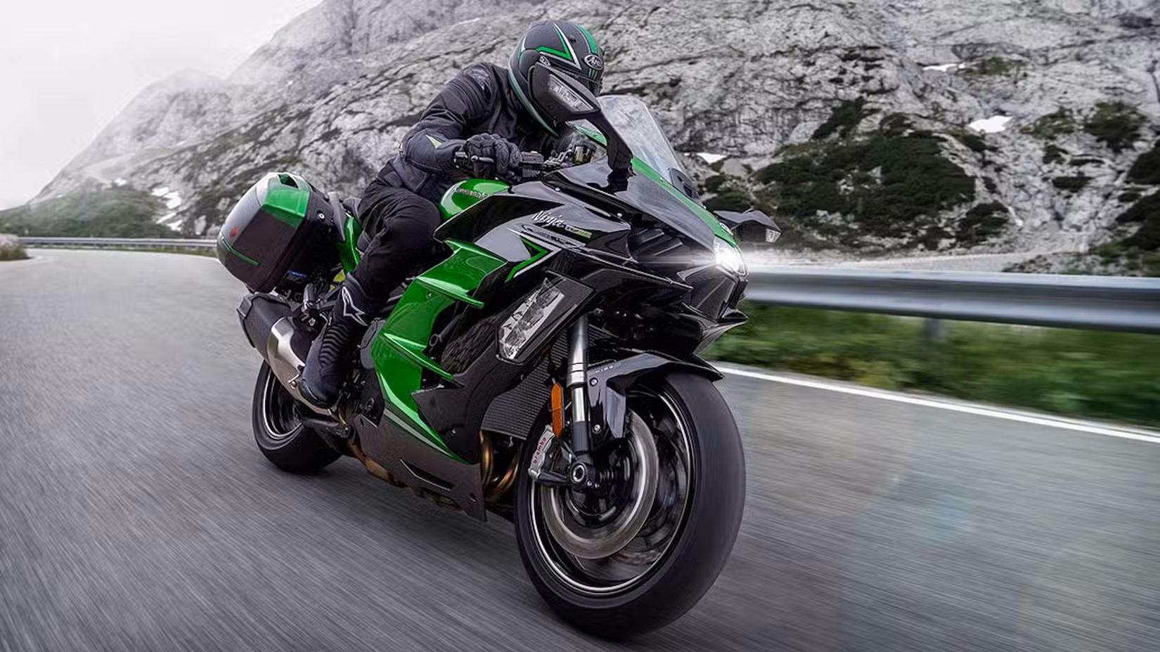 Green Kawasaki Ninja H2 SX cornering fast in the mountains