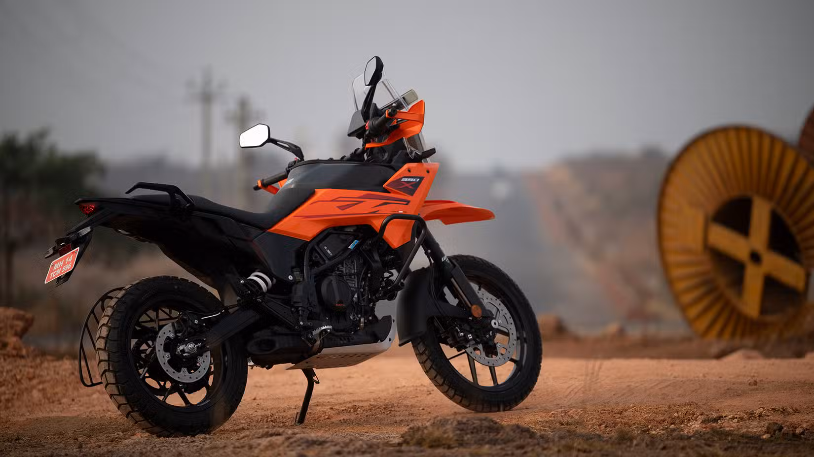 Outdoor static shot of orange KTM 390 Adventure X, rear right third quarter