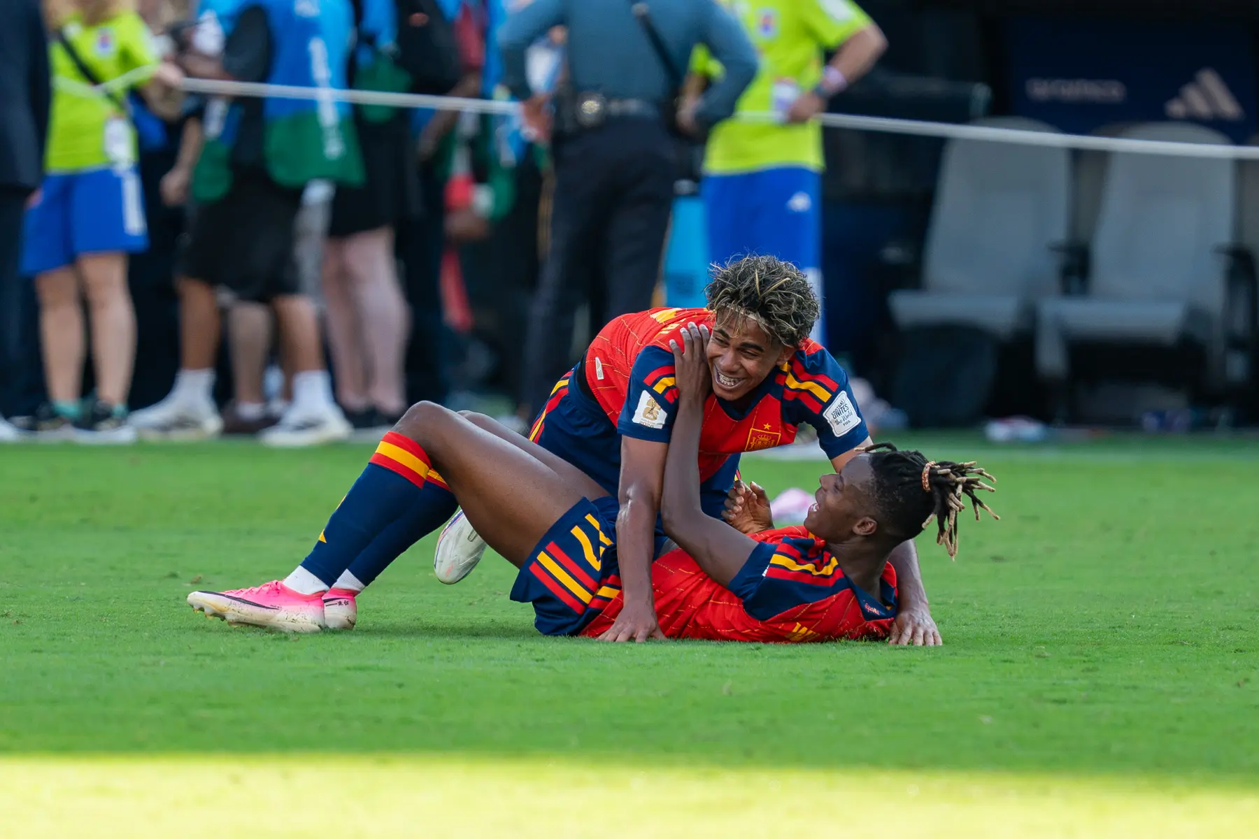 Lamine Yamal celebrating on the pitch with a teammate during a match for Spain.