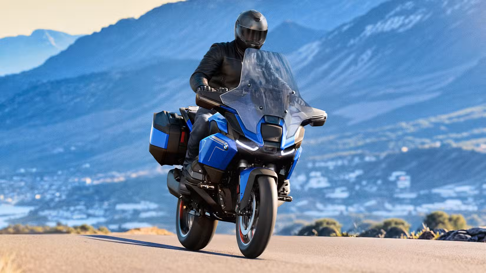 Rider on a 2026 BMW R 1300 RT cruising on a mountain road