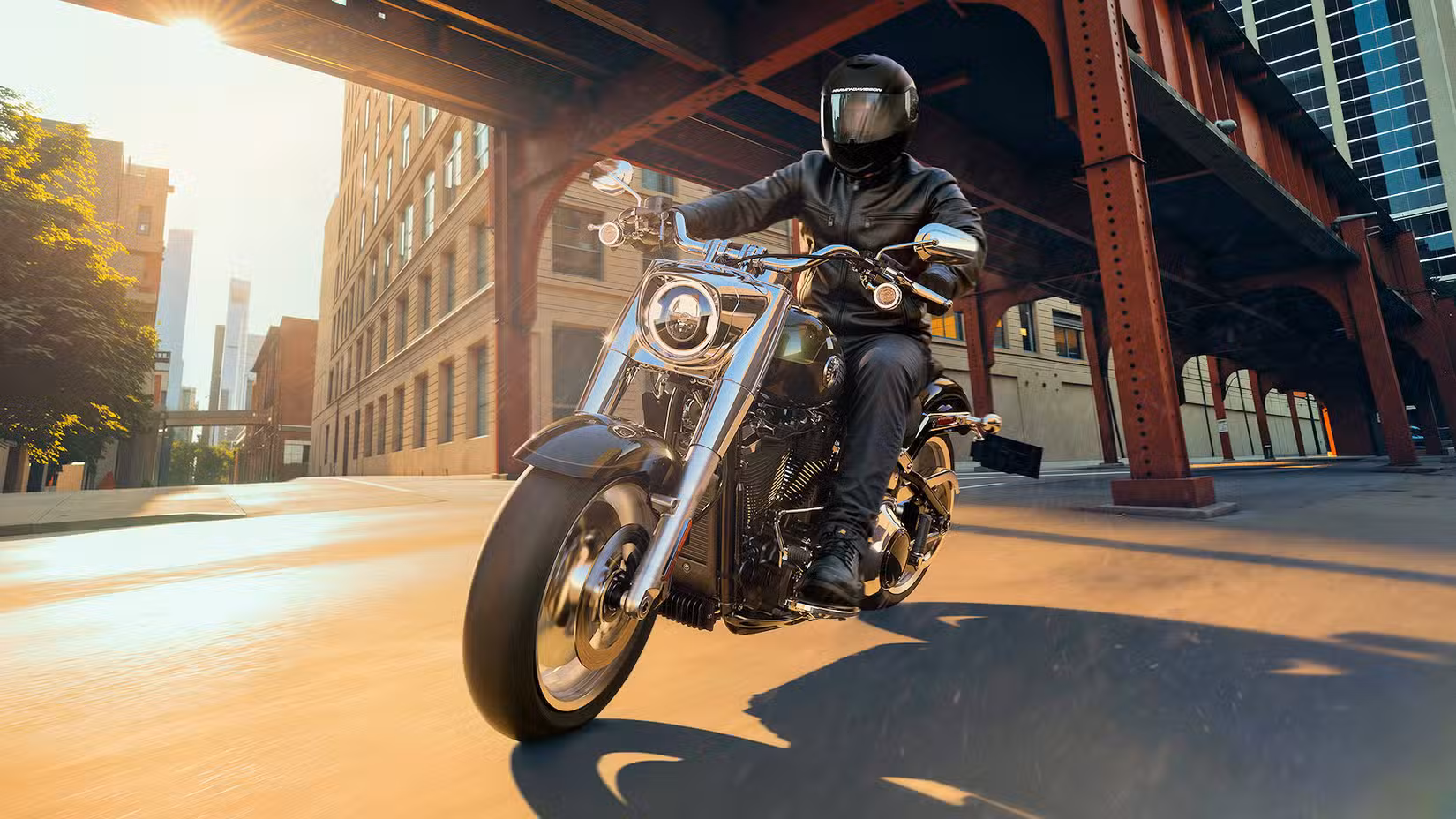Rider on a 2026 Harley-Davidson Fat Boy cruising through town