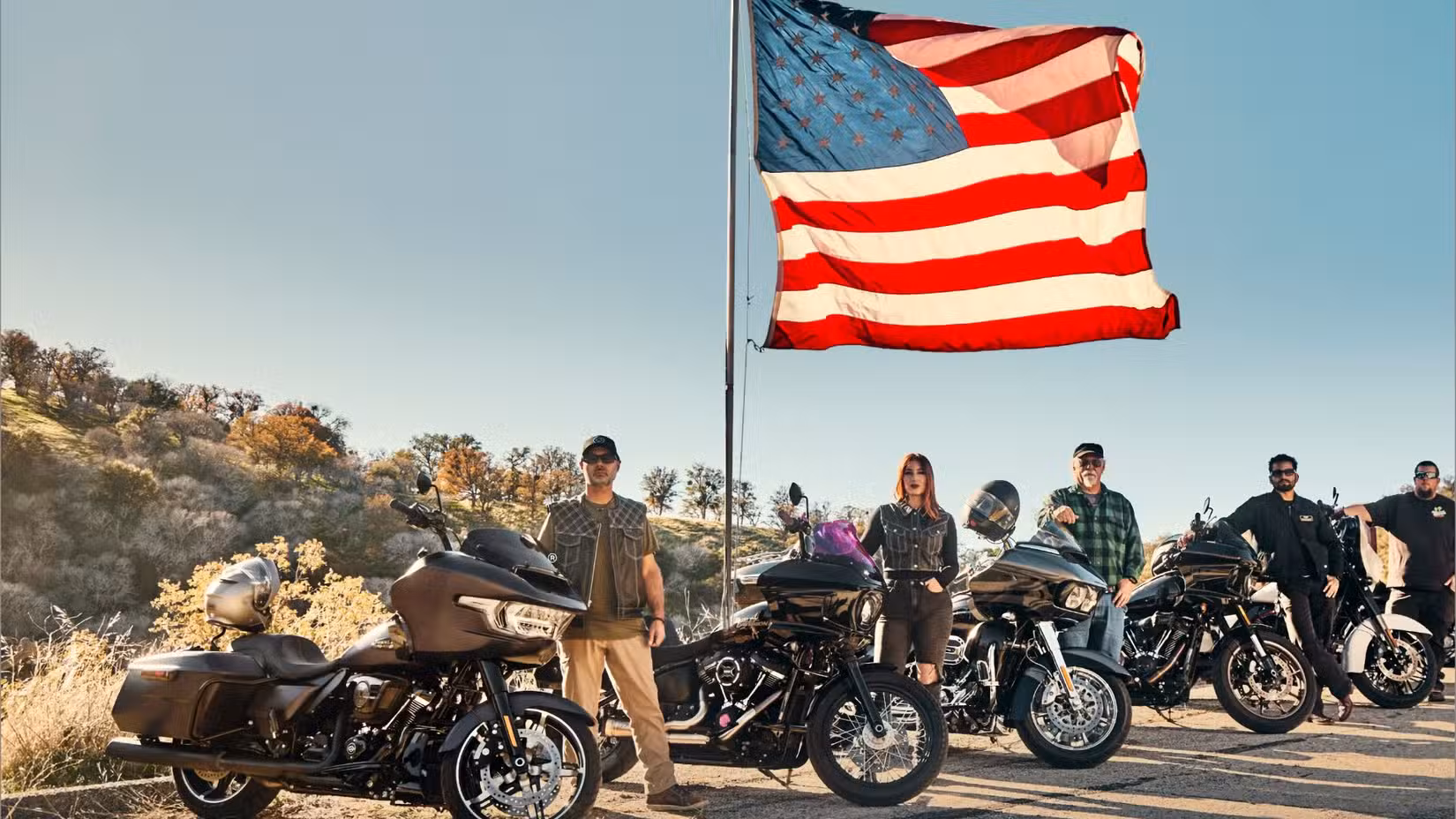 Riders lined up with Harley-Davidson motorcycles in front of an American flag to promote the Let;s Ride challenge 2026