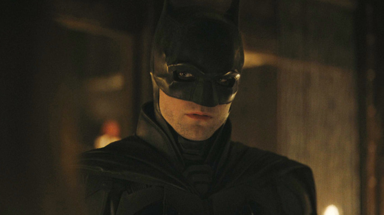 Robert Pattinson's Batman looks across at someone off screen in The Batman