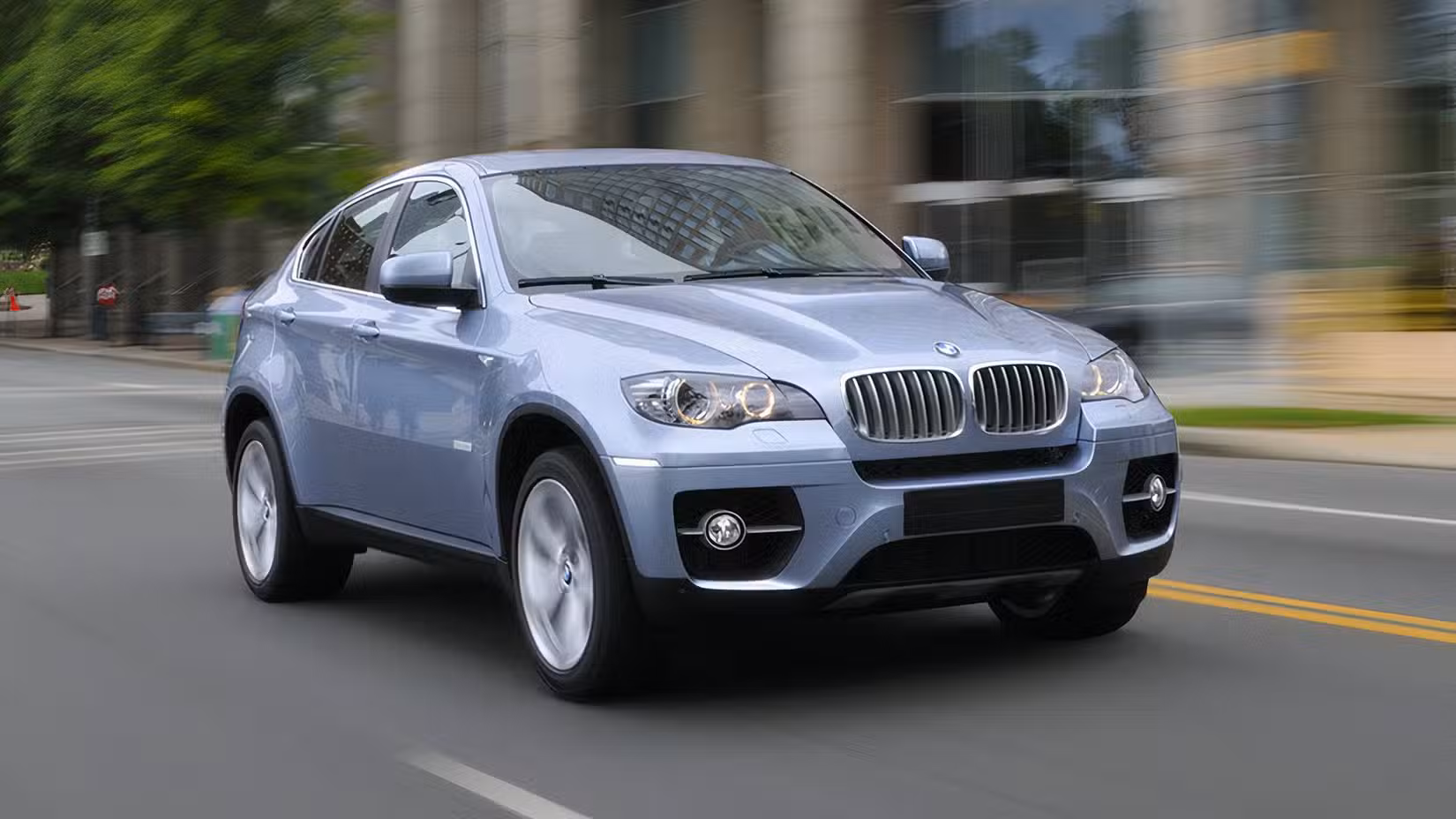 Driving shot of a silver 2010 BMW ActiveHybrid X6 on a city street in front 3/4 view