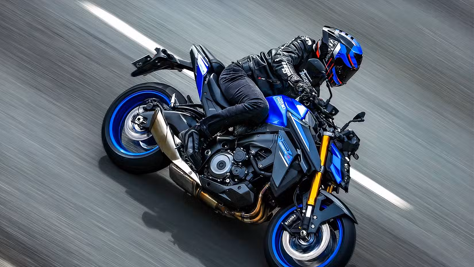 Rider cornering hard on a Suzuki GSX-S1000