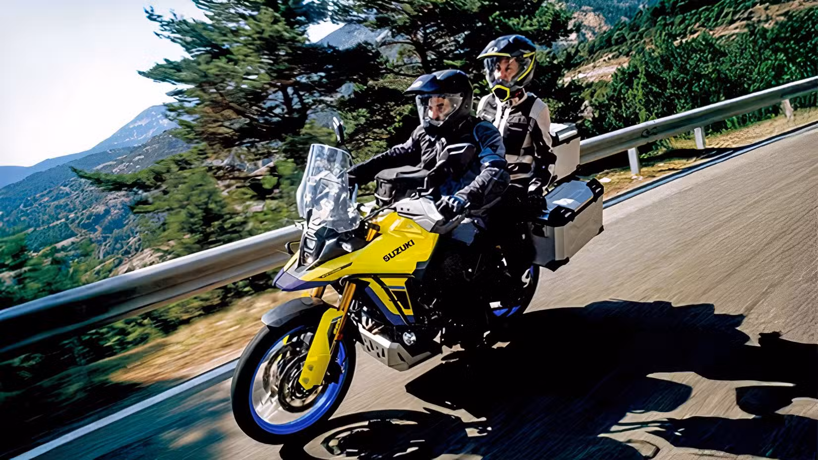 Tracking shot of a Suzuki V-Strom 800DE Touring being ridden two-up