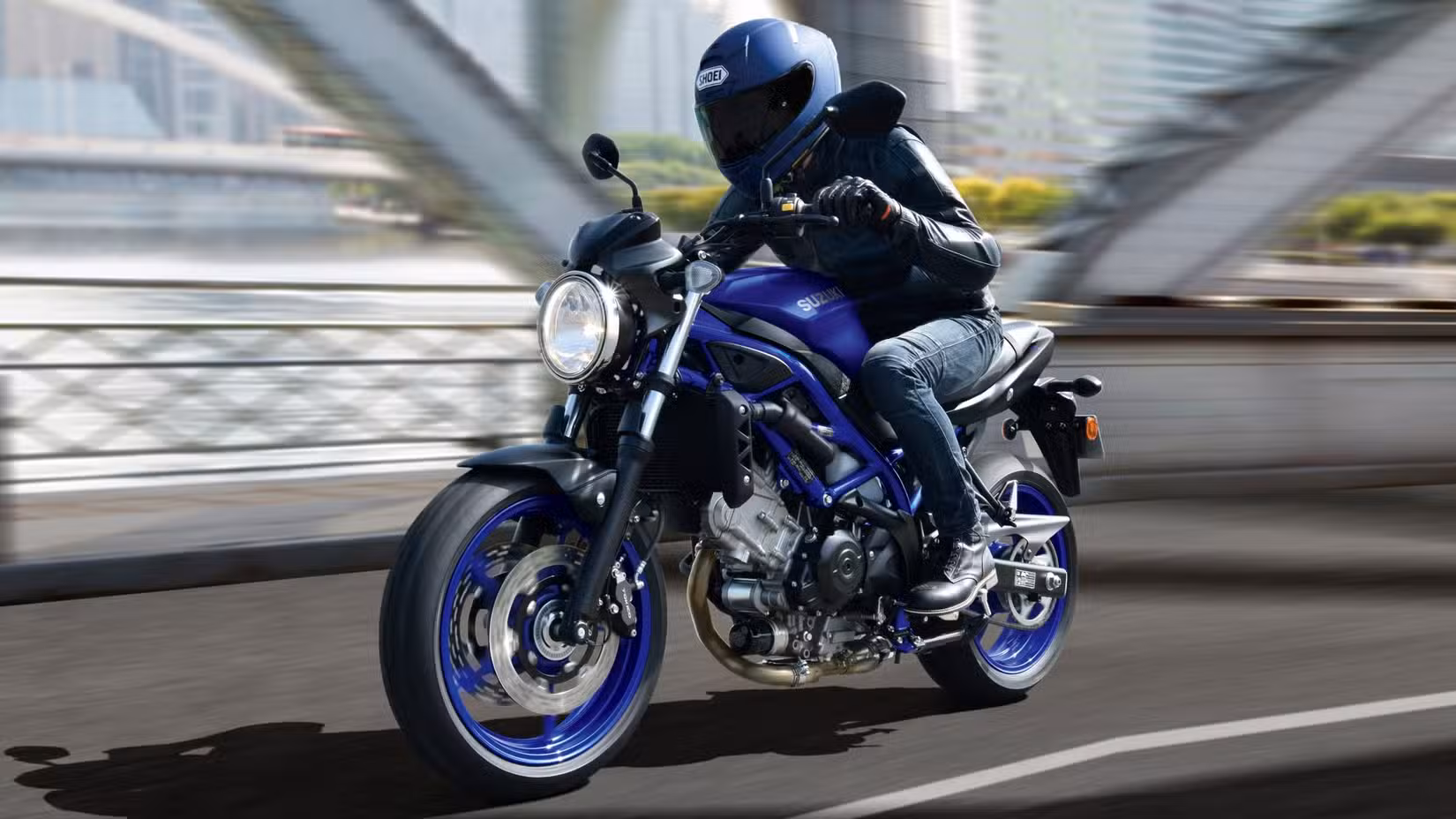 Action shot of a Suzuki SV650 riding over a bridge