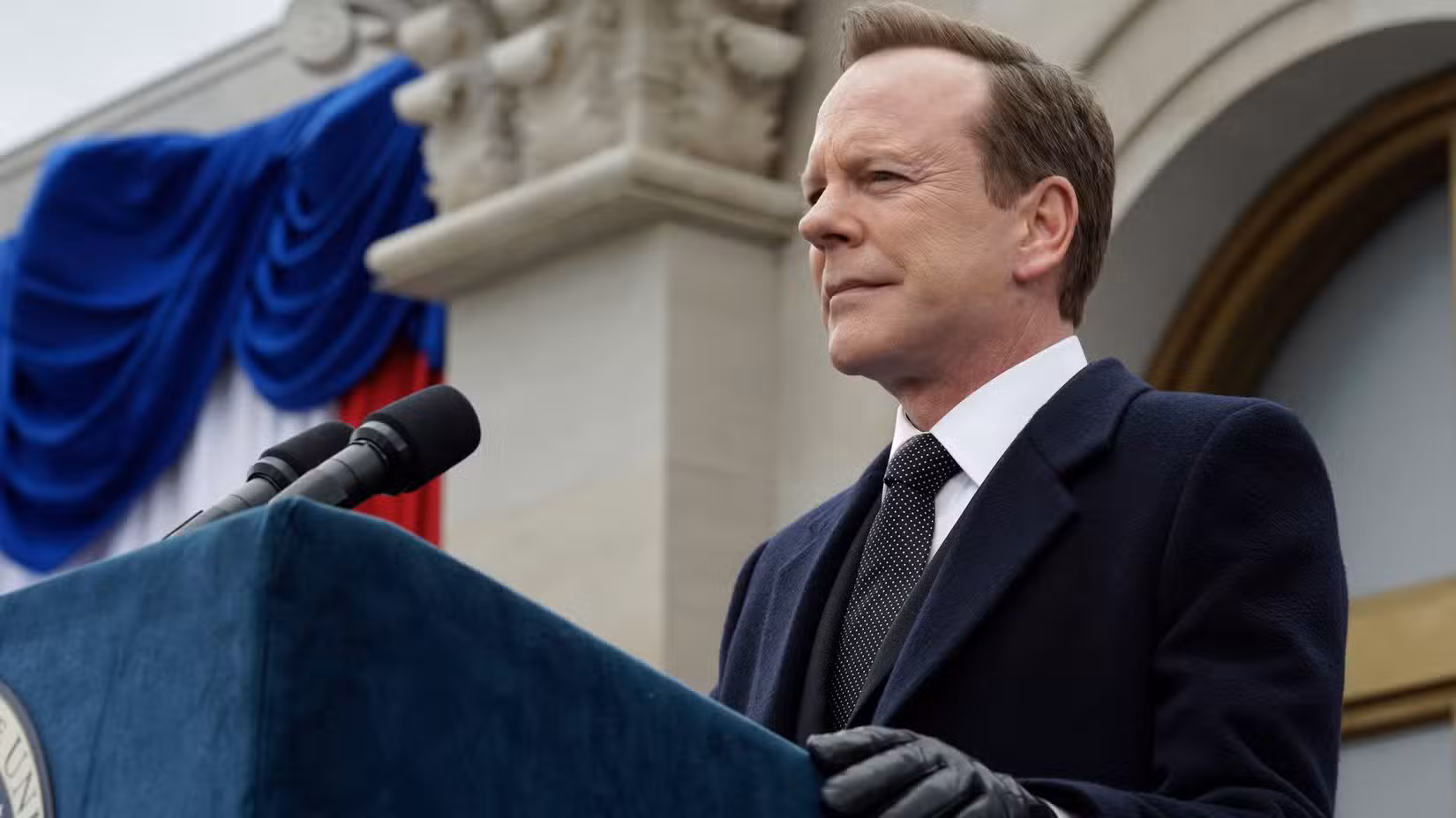 Tom Kirkman (Kiefer Sutherland) speaking at a podium in Designated Survivor.