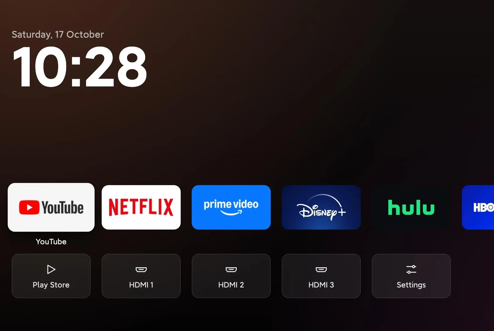 A TV operating system home page without ads and large tiles to select different streaming services and TV inputs.