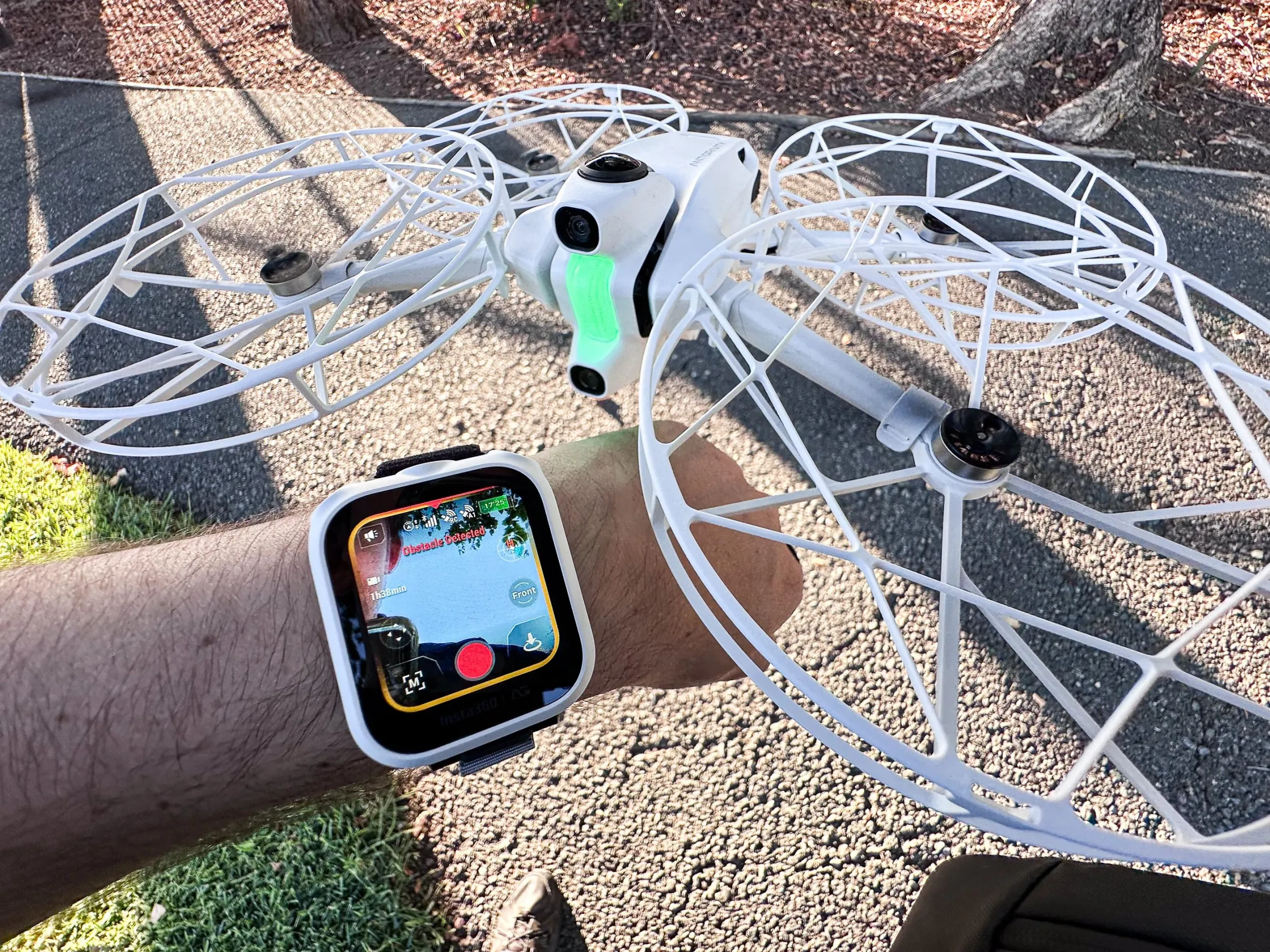 A wristwatch screen controls a drone flying right above the person’s hand.