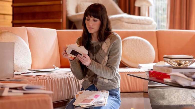Lowen looking at papers in Verity's office in Verity