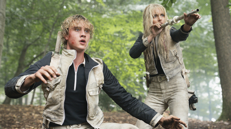 Haymitch looking shocked and Maysilee aiming a poison dart in The Hunger Games: Sunrise on the Reaping