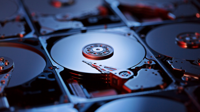 Multiple disassembled HDDs with their internal platters exposed.