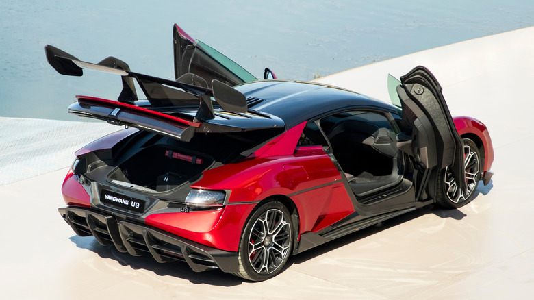 Top rear three quarter shot of a red Yangwang U9 with the doors and trunk open
